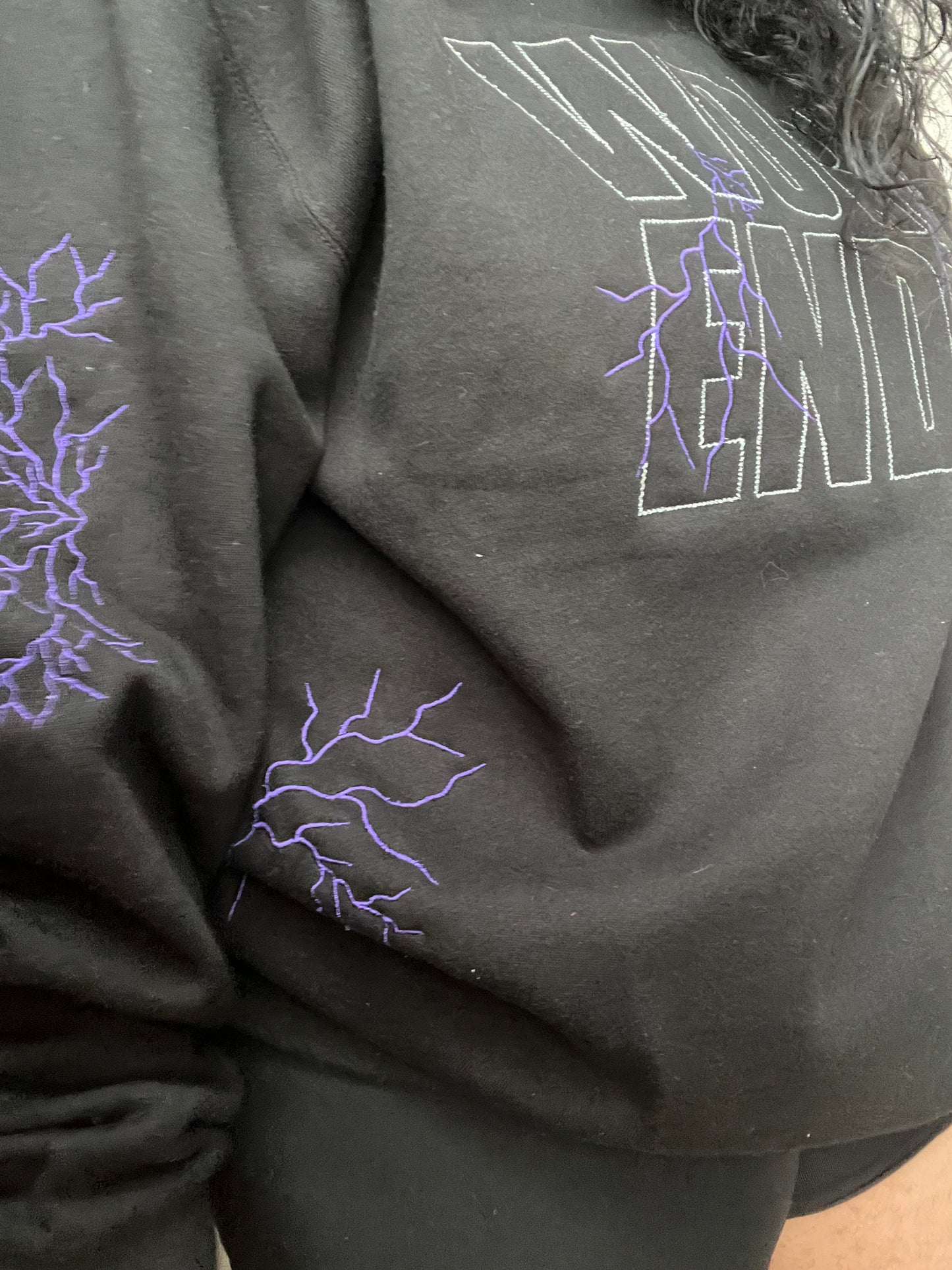 Black sweatshirt with white words and purple lightning on the back